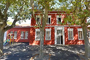 Bâtiment avec façade rouge et entourage blanc pour les fenêtres