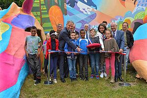 Groupe d'enfants et maire d'Oullins coupant un ruban d'inauguration