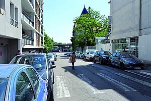 Rue avec voitures en stationnement et immeubles