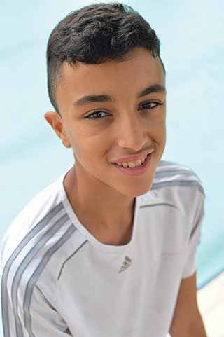 Jeune garçon souriant aux cheveux bruns.